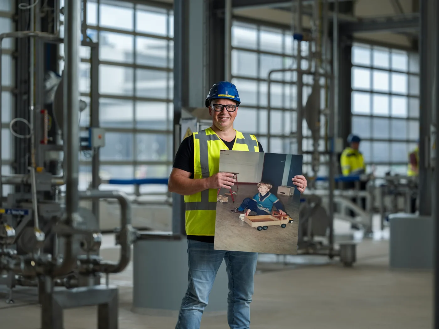 Werknemer in veiligheidskleding staat in een fabriekshal