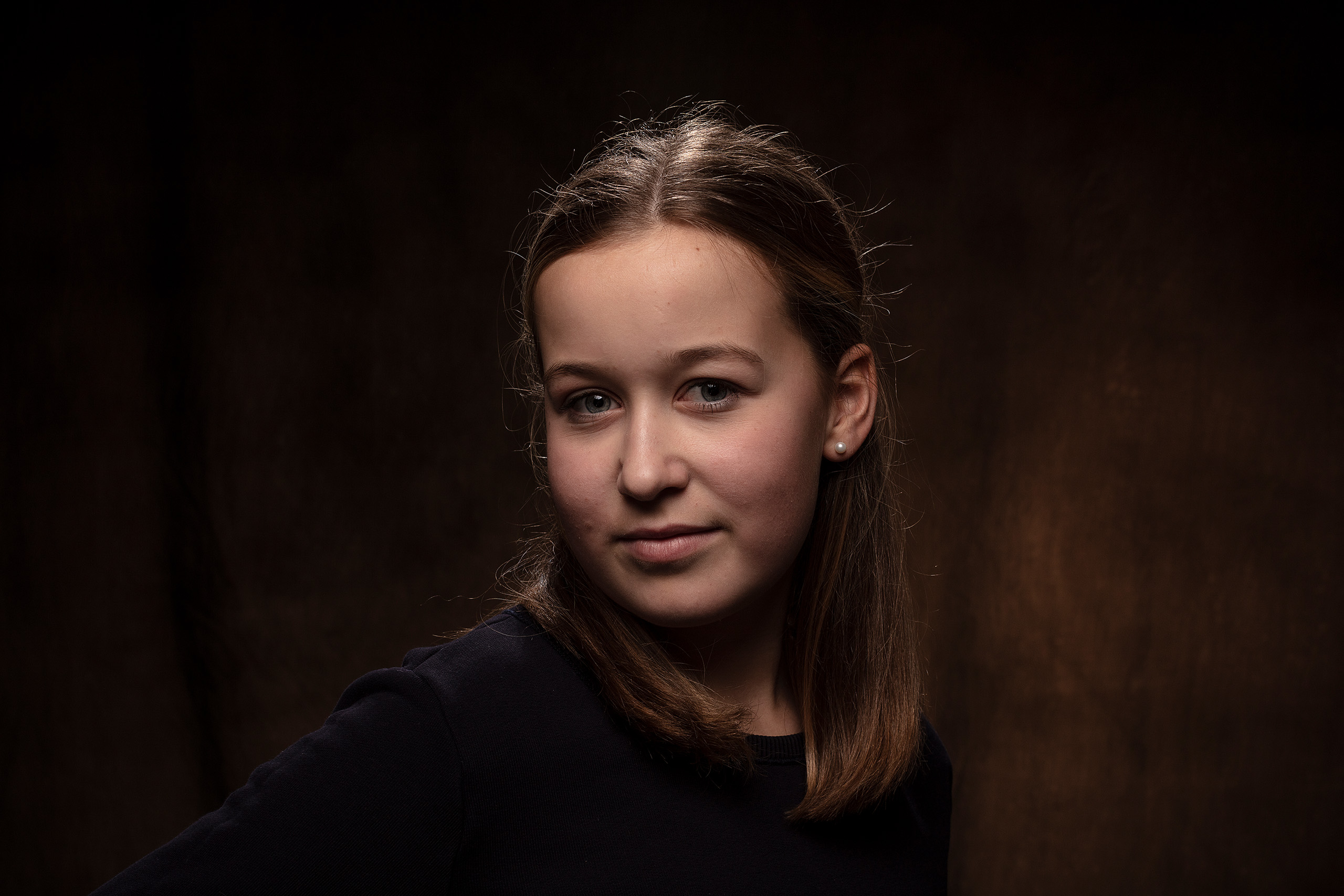 Portret van dame uit Heerenveen voor donkere achtergrond gefotografeerd door Daniel Wenzel Fotografie